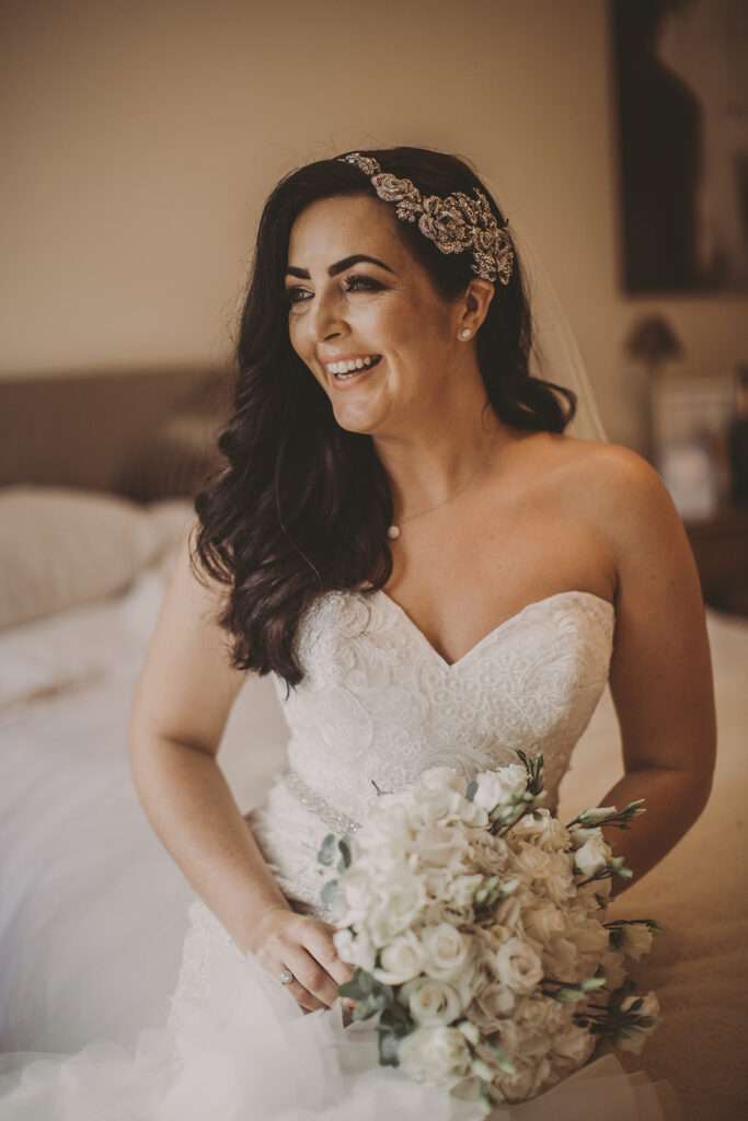 bride in wedding dress with flowers, laughing