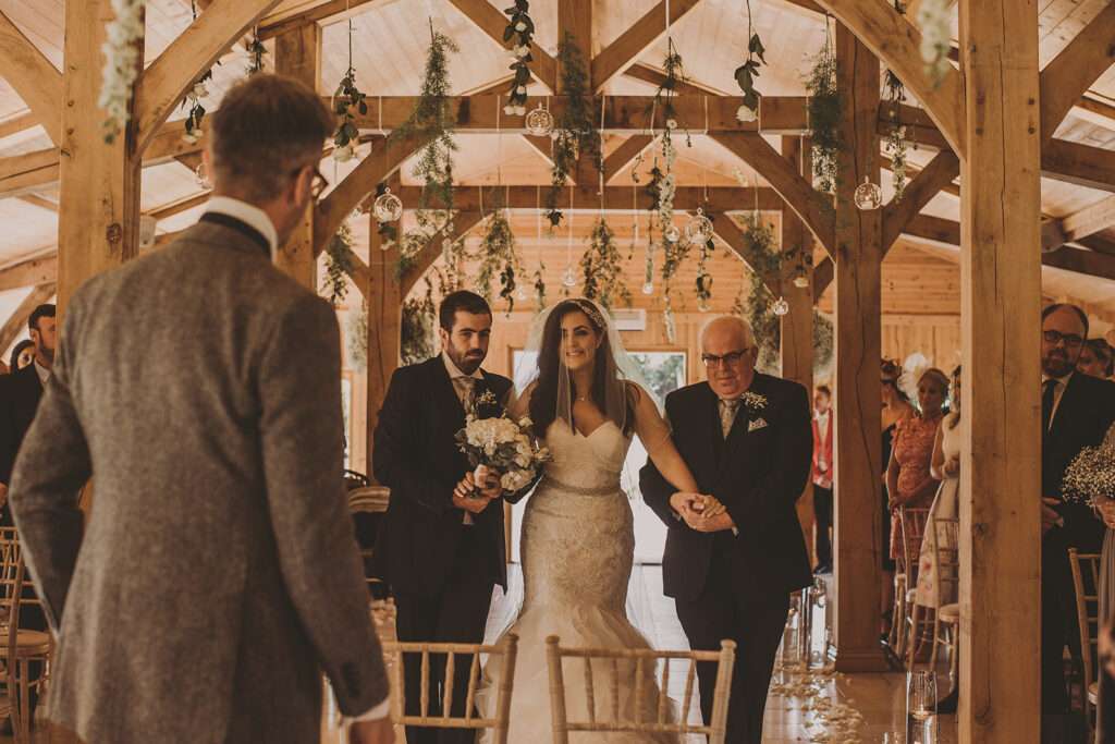 couple walking towards guests at their Colshaw Hall wedding ceremony