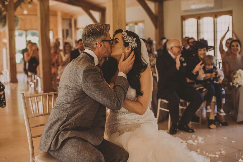bride and groom kiss during wedding ceremony at Colshaw Hall