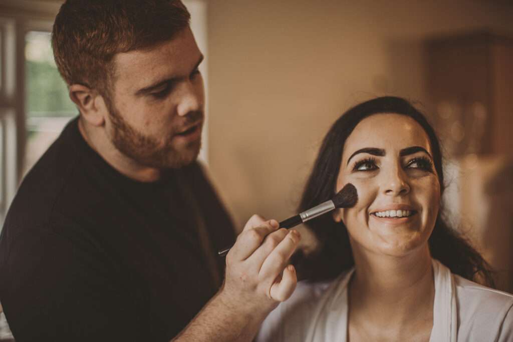 bride has make-up applied whilst getting ready for her wedding at Colshaw Hall