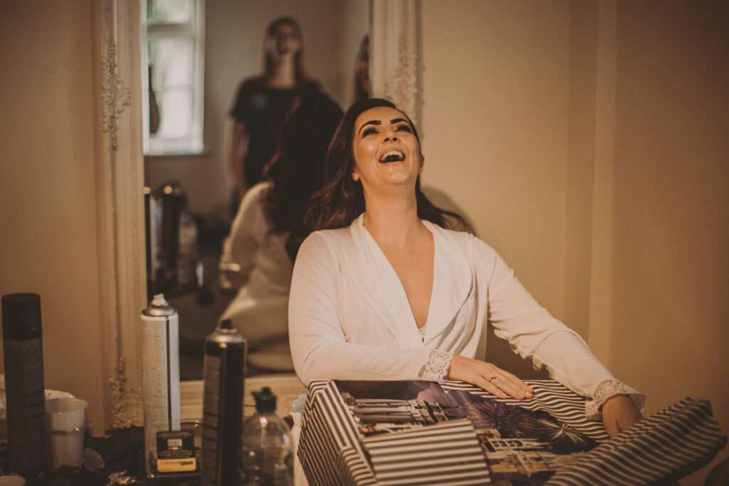 bride opening gift during bridal preparations at Colshaw Hall