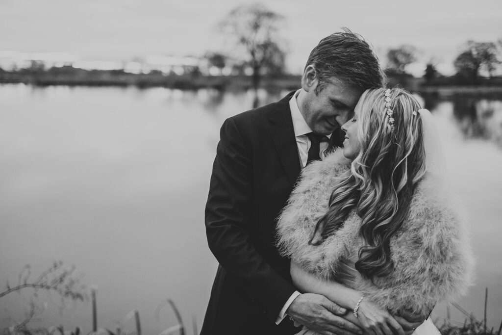 bride and groom embrace during their wedding day portraits