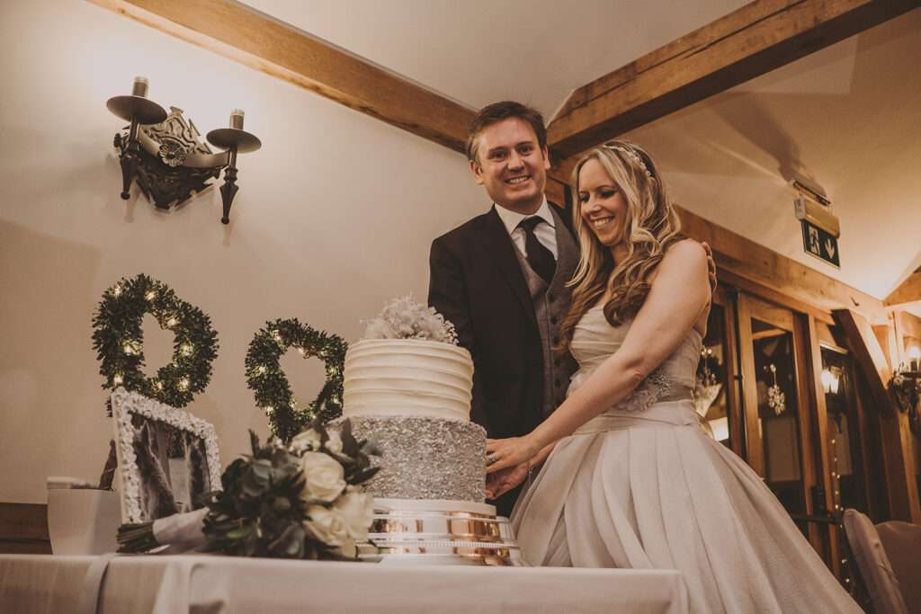 bride and groom cut wedding cake at Sandhole Oak Barn