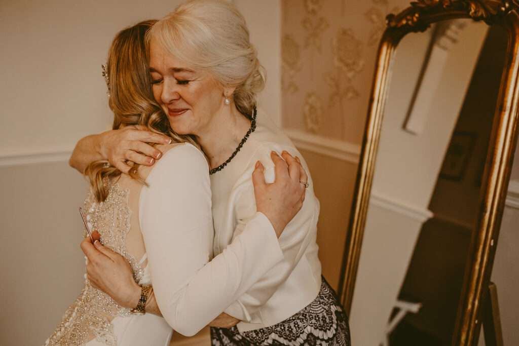 bride and mother embrace during bridal preparations