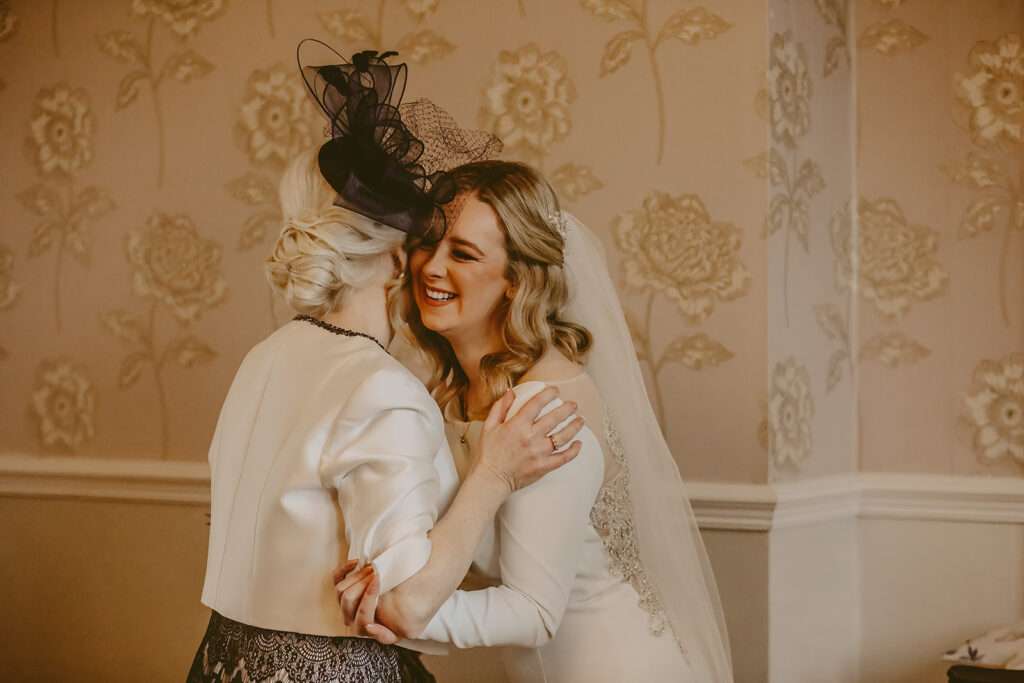 bride embraces mum for a hug during bridal preparations