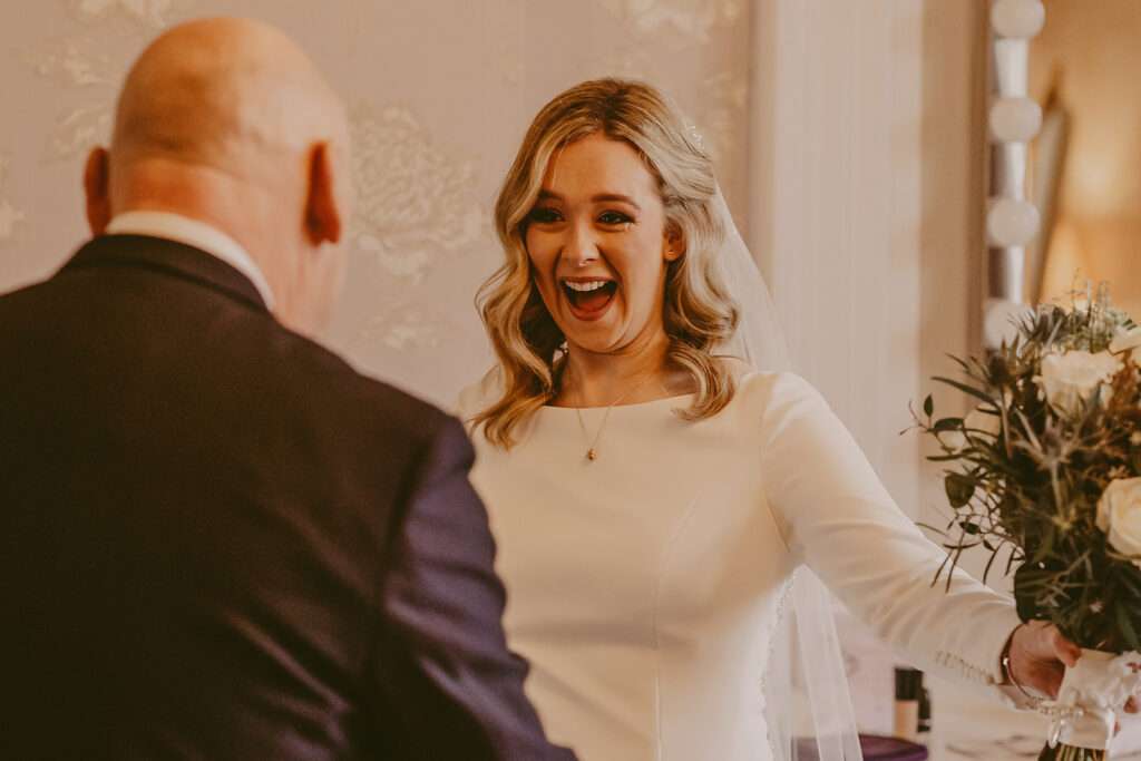 bride greets dad as he sees his daughter in her wedding dress