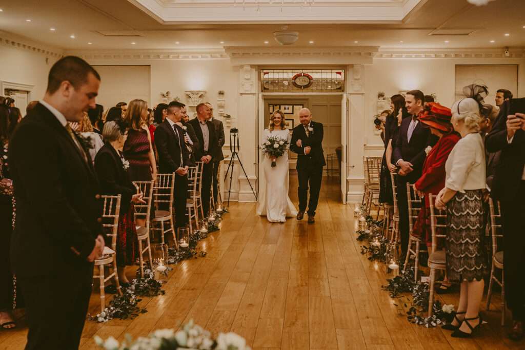 bride walks down the aisle with her dad