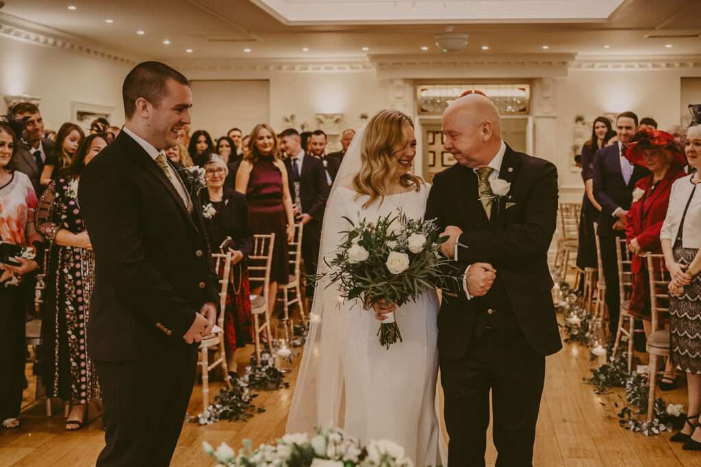 bride and dad arm in arm in the aisle at Ashfield House