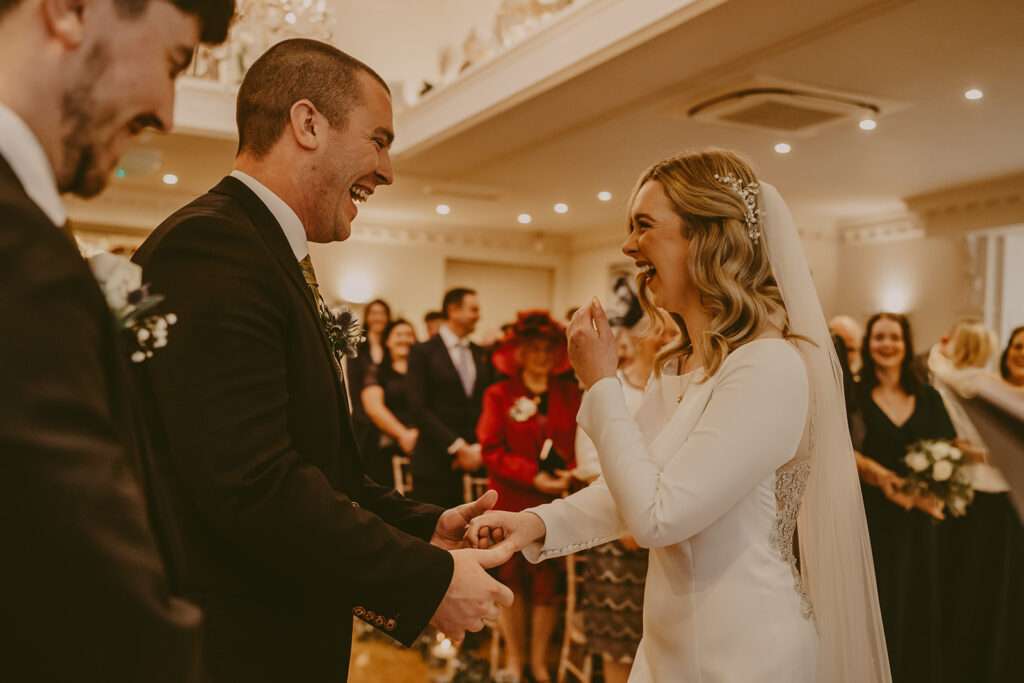 bride holds hands with groom before the wedding ceremony at Ashfield House