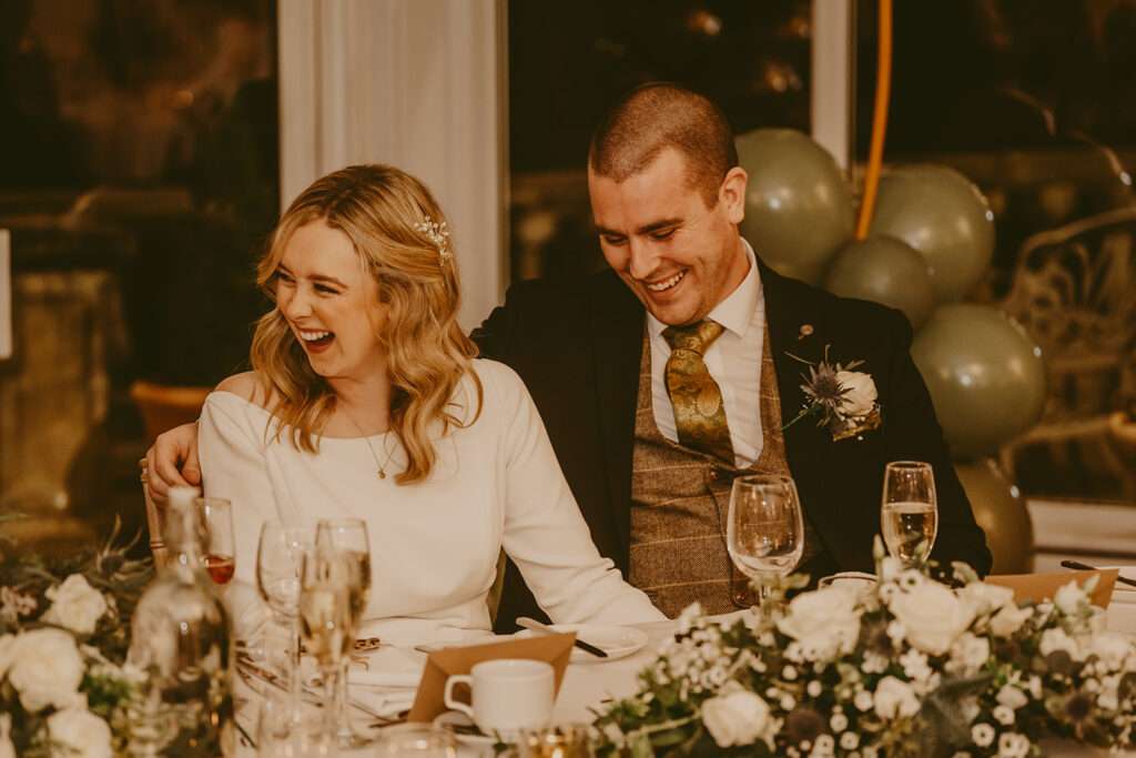 bride and groom laughing during speeches