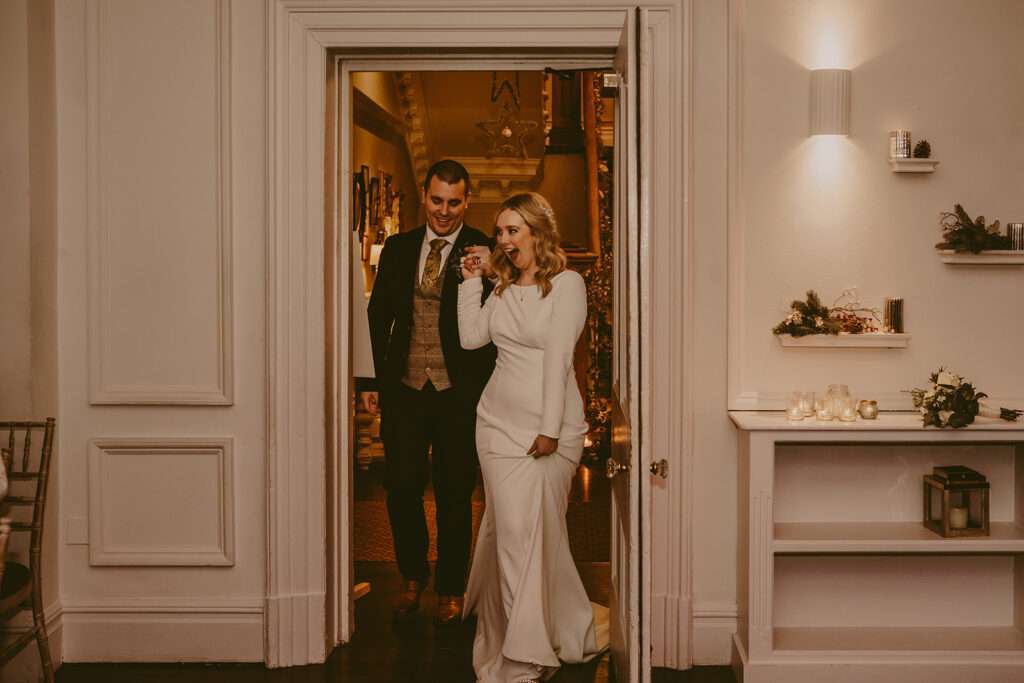 bride and groom walk into the evening wedding reception together