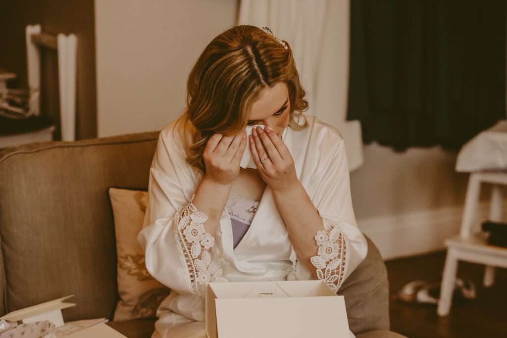 bride crys as she opens a present from the groom